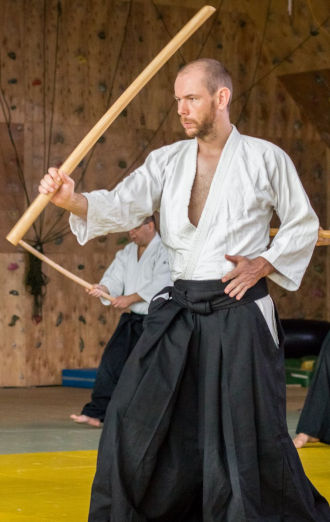 Stephan Schroeder im Aikido-Tainingsanzug ein Bokken haltend